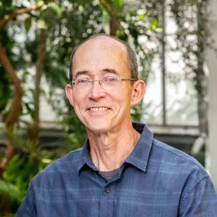 Thin man with gray hair and glasses.