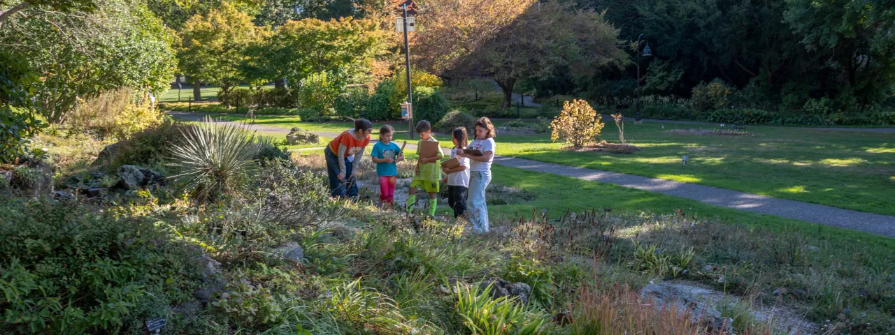 volunteer and students learning in the rock garden