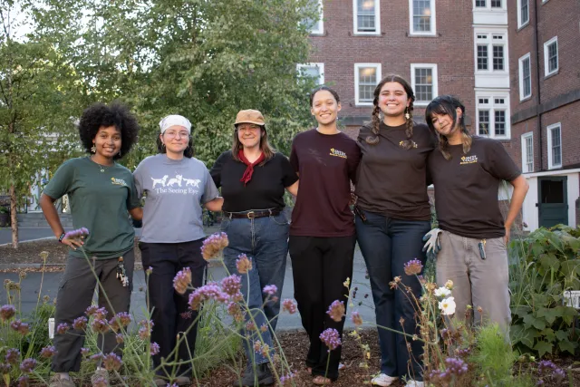 Group of students and staff standing in a row for a posed group photo. 