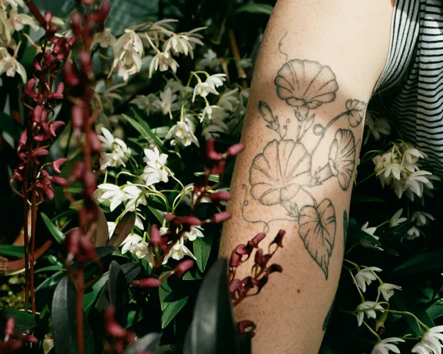 Image of forearm with flower tattoo on it.