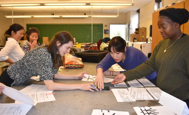 Three students looking at materials on a table.