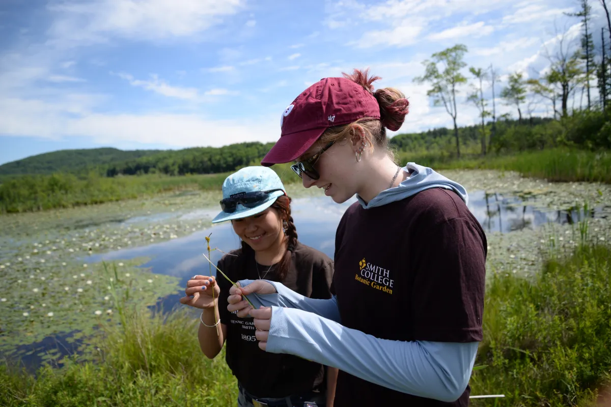 Two students in field with caps on.