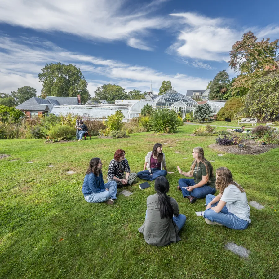 group of students sitting in the grass in front of Lyman