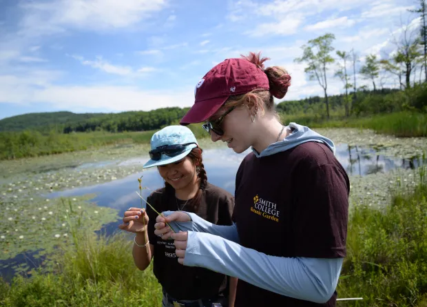 Two students in field with caps on.