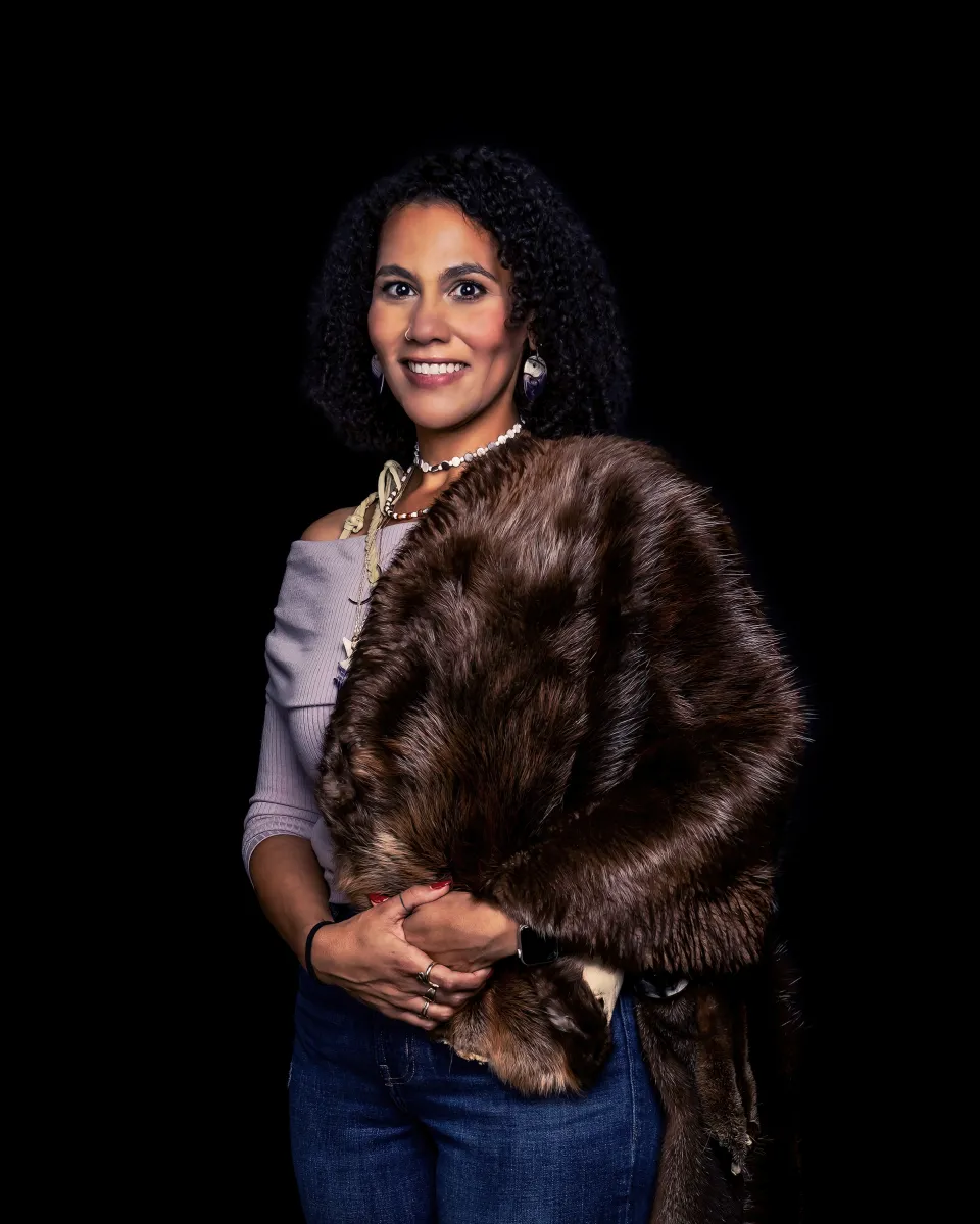 woman wearing a dark brown fur shawl with a gray shirt underneath