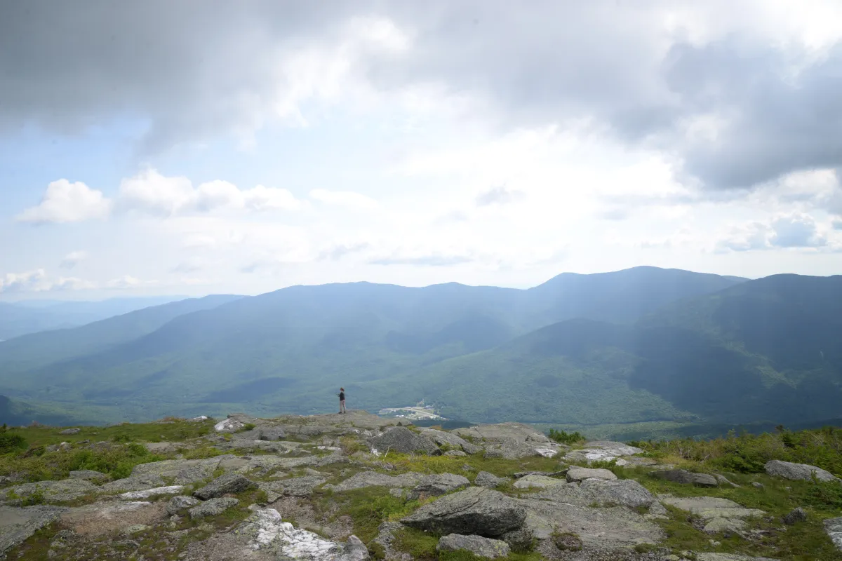 Figure standing at overlook on mountain.