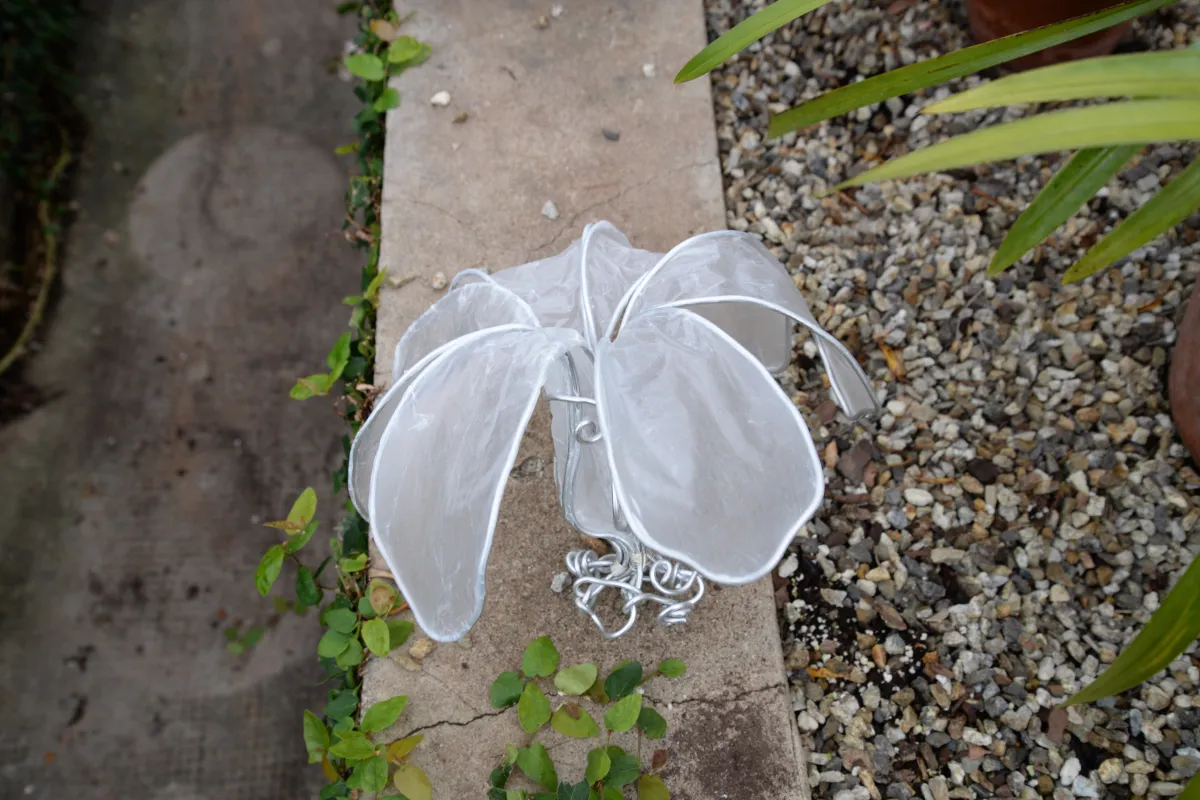 Big paper flower on cement wall.