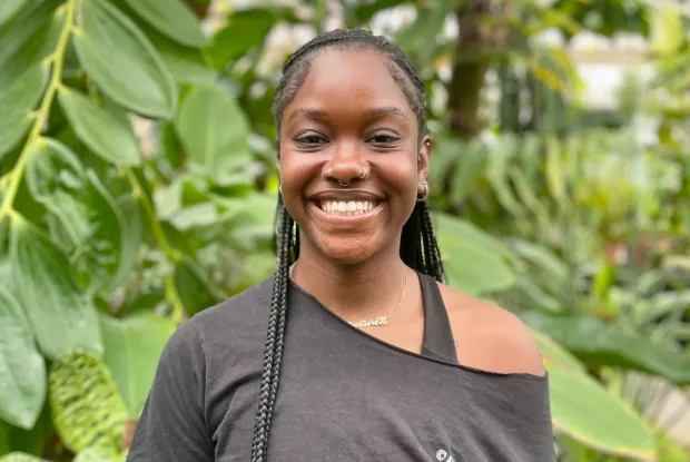 Student in black shirt smiling at camera.